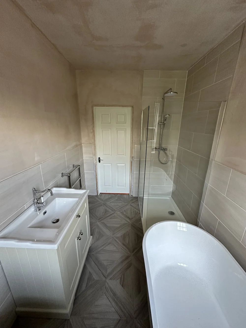 Family bathroom mid-renovation with fresh plaster, shaker vanity, walk-in shower and freestanding bath — bathroom renovation Woking