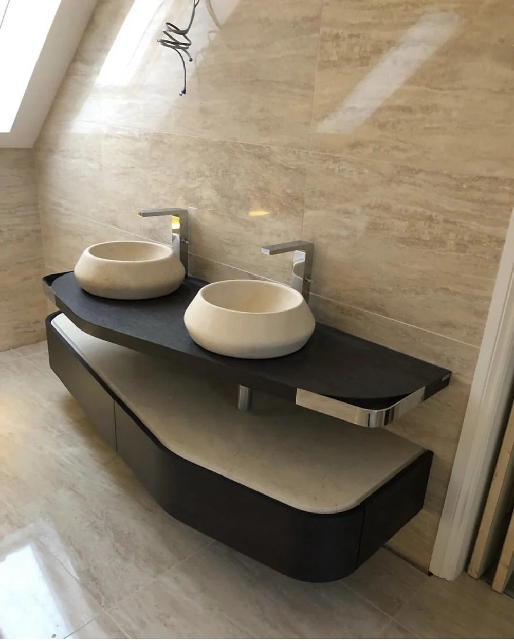 Bespoke twin stone vessel basins on curved slate vanity in travertine ensuite — bathroom design Woking
