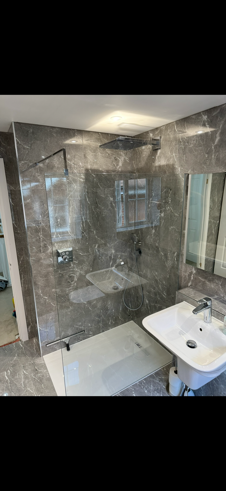 Grey marble walk-in shower with rainfall head and frameless glass — wet room Woking