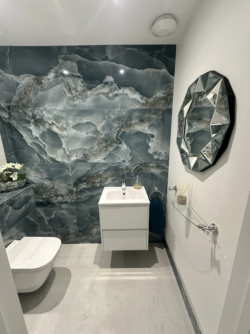 Luxury cloakroom with blue onyx feature wall, wall-hung WC and jewel-cut mirror — bathroom installation Woking