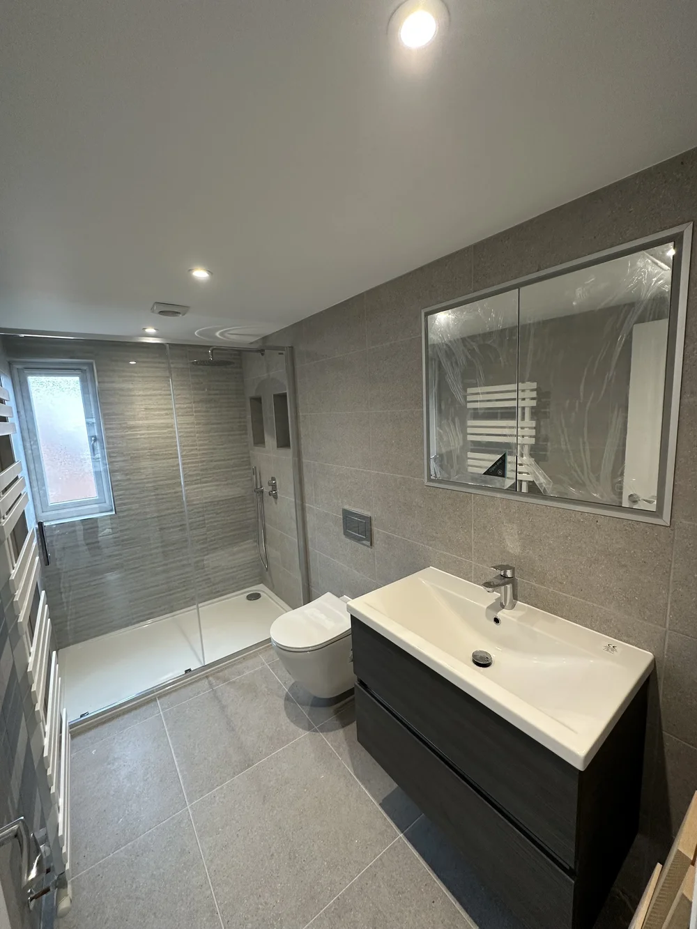 Contemporary shower room with graphite vanity, walk-in shower and mirrored cabinet — bathroom renovation Woking