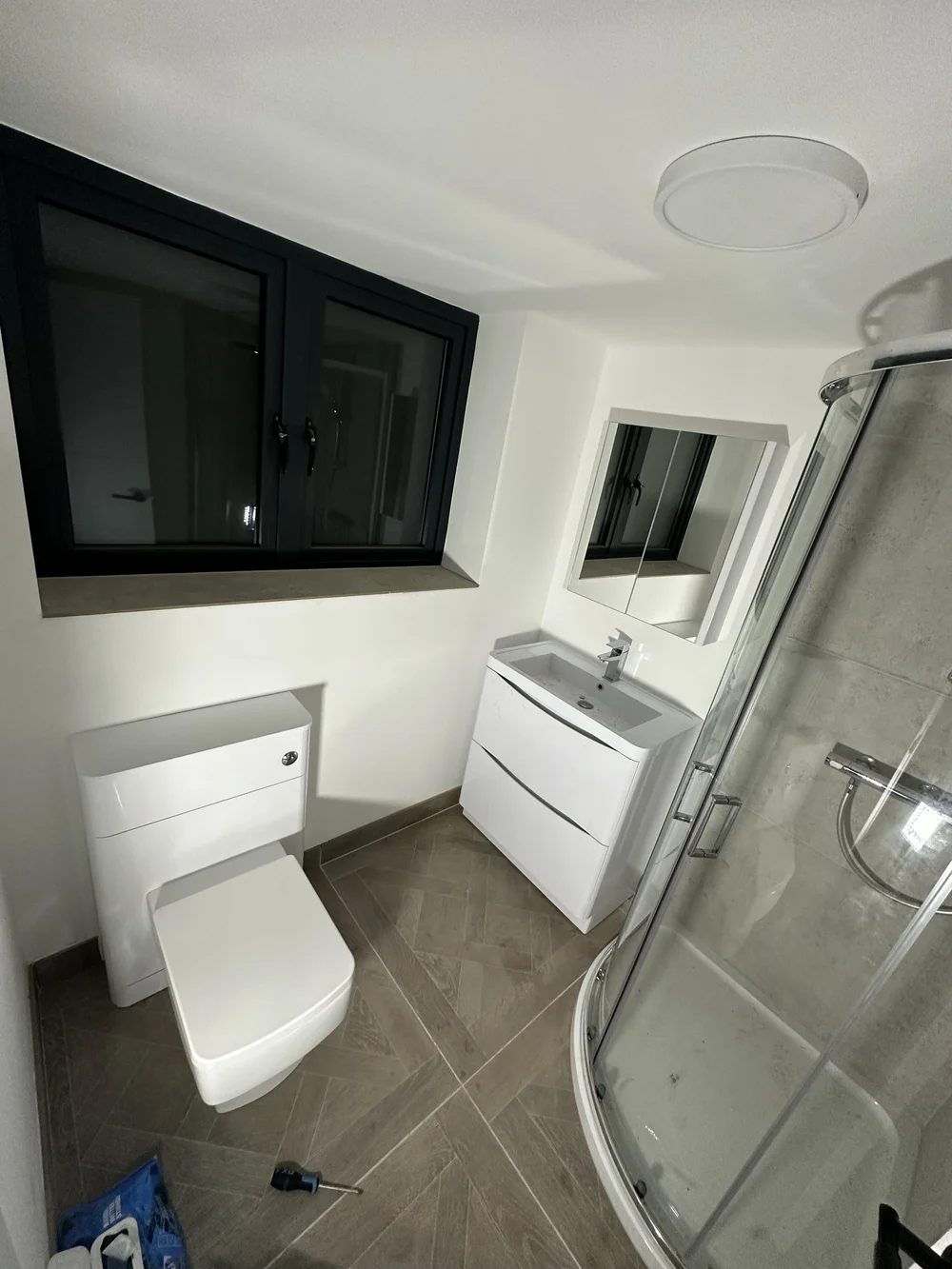 Compact ensuite with quadrant shower enclosure, wall-hung vanity and back-to-wall WC — bathroom installation Woking