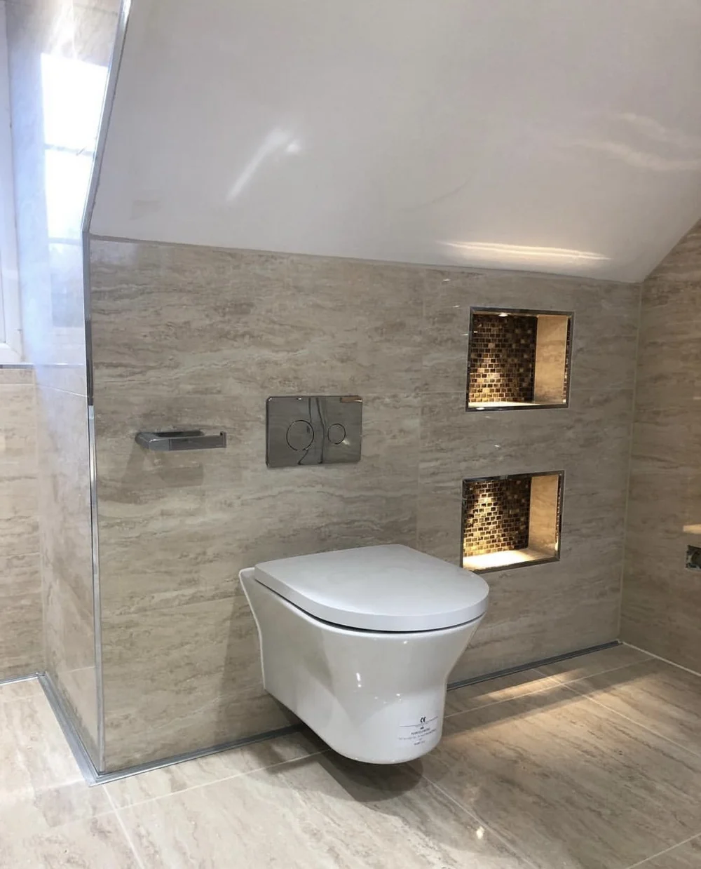 Travertine wet room with wall-hung WC and illuminated mosaic niches — bathroom renovation Woking