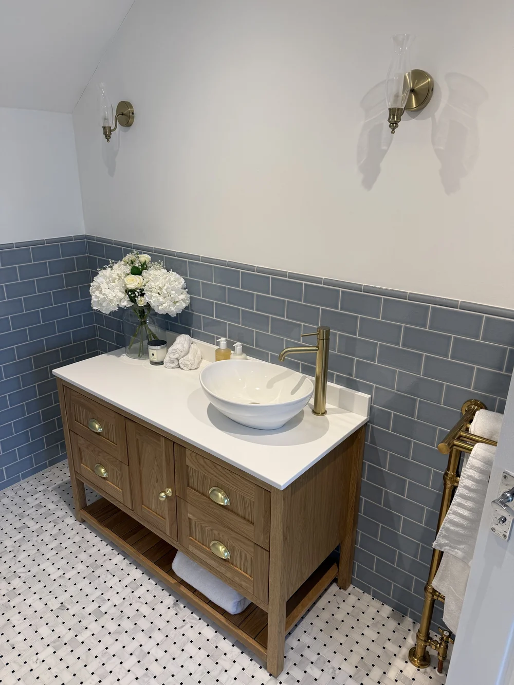 Oak vanity with vessel basin, brass tap and blue metro tiles — bathroom design Woking