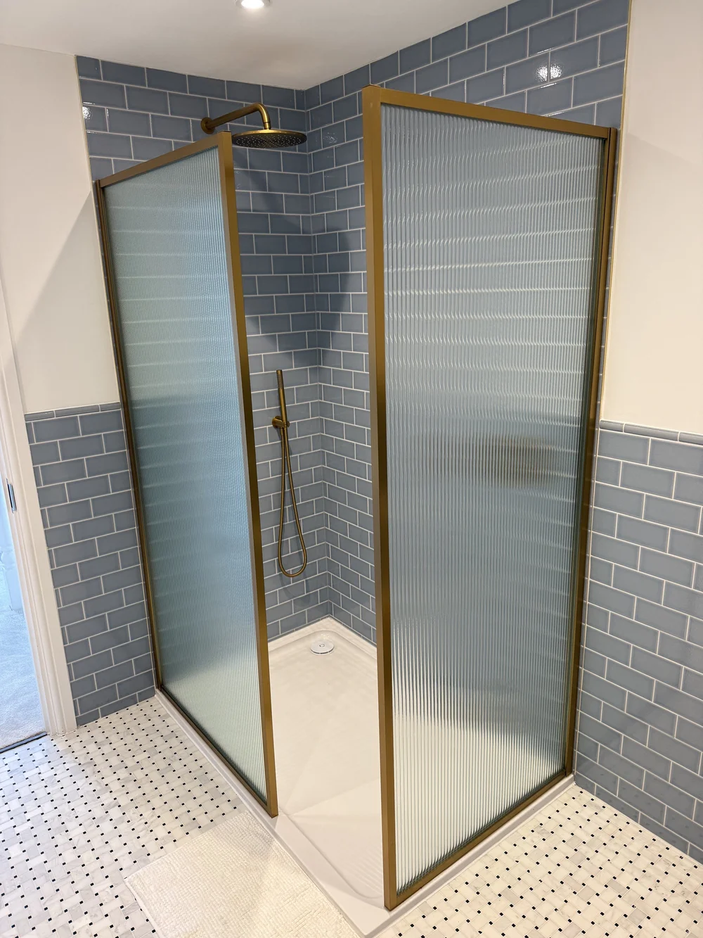Blue metro tile walk-in shower with brushed brass fluted screens — Woking bathroom fitters