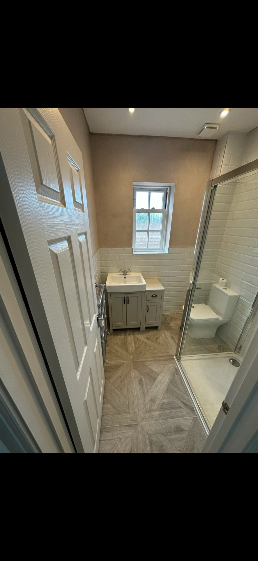 Compact shower room with shaker vanity, beveled metro tiles and chevron parquet floor — bathroom installation Woking