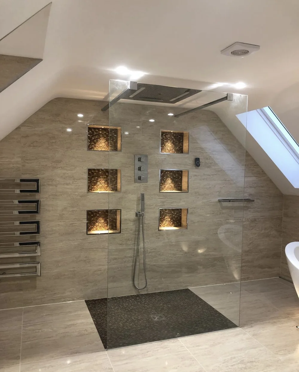 Luxury loft wet room with travertine walls, mosaic niches and frameless glass screen — Woking bathroom fitters